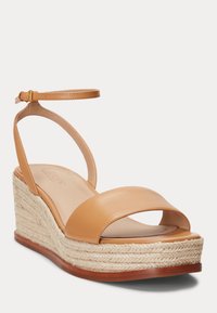 Bruna läder kilklackssandaler med en rem runt vristen, öppen tå och en texturerad juteplattform. Slät yta med en brun sula.