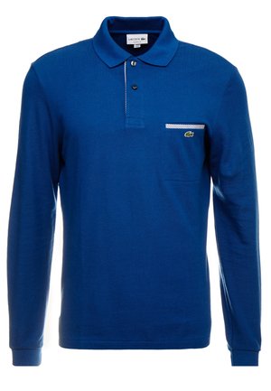 Niebieska koszulka polo z długim rękawem, plisą na dwa guziki, mała kieszonka na lewej piersi wykończona pasiastą tkaniną oraz zielone logo krokodyla Lacoste.