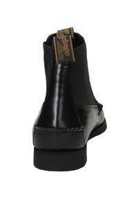 Stivaletto in pelle nera con pannelli elastici sui lati e suola in gomma piatta. Presenta una targhetta con logo dorato nella parte superiore e cuciture lungo i bordi.