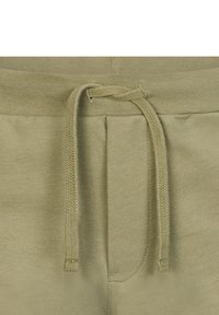 Pantaloni della tuta verde oliva con tessuto testurizzato, dotati di un elastico in vita con lacci e due tasche frontali, che enfatizzano comfort e semplicità.