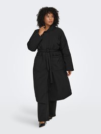 Svart kappa med bälte och hög krage, med stora framfickor och knälång design. Slät tyg och avslappnad passform.