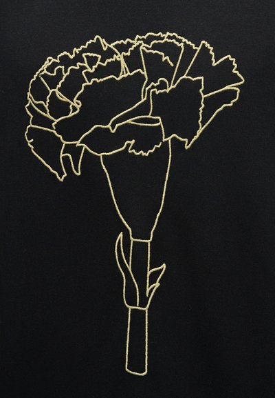 Μαύρο ύφασμα με κεντητή περίγραμμα άνθους γαρίφαλου σε κίτρινο χρώμα, που αναδεικνύει λεπτομέρειες όπως πέταλα και φύλλα.