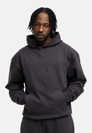 Dark gray hooded sweatshirt with a textured fabric, kangaroo pocket, and relaxed fit. Features wide cuffs and an adjustable hood.