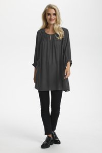 Tunique grise à manches longues avec un col rond et un détail en forme de clé, assortie à un pantalon noir slim et des chaussures noires, texture lisse.
