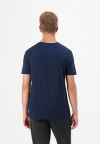 T-shirt bleu marine à manches courtes avec un col rond, texture lisse et design uni ; vu de l'arrière sans logos visibles.