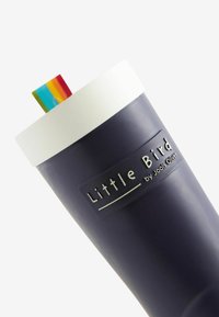 Tasse bleu marine avec un bord blanc et une paille colorée. Présente la marque "Little Bird by Jools Oliver" sur le côté en lettres en relief.