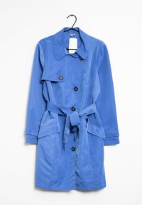 Blå knälång trenchcoat med knappar, bälte vid midjan, fickor med luckor och bred krage, hängande på en svart galge mot en vit bakgrund.