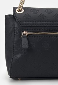 Svart texturerad handväska i syntetmaterial med präglade mönster, en dragkedjeficka med silverfärgad hårdvara och en kedjestropp.