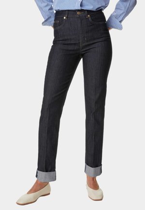 Jean en denim foncé taille haute avec une coupe droite, ourlets retroussés et détails en métal doré. En matériau coton avec un léger effet stretch.