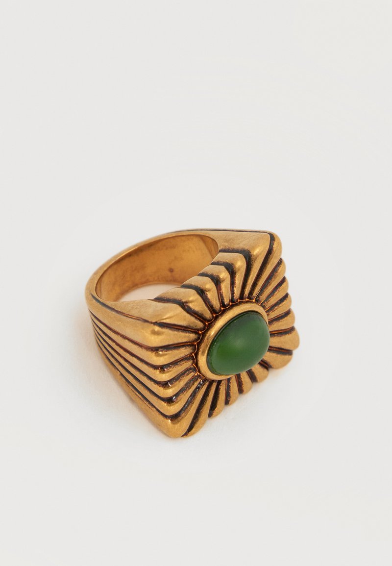 Δαχτυλίδι σε χρυσαφί χρώμα με τετράγωνο μοτίβο σε σχήμα ηλιαχτίδας και στρογγυλεμένο πράσινο λίθο στη μέση.