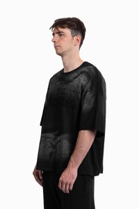 Černé oversize tričko s barevným přechodem a vyraženým textem na přední straně. Krátké rukávy a volný střih. Měkká textura látky.