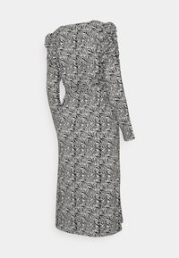 Vestido de mangas longas em estampado de zebra preto e branco, com ombros volumosos e cintura ajustada por um cinto, apresentando uma silhueta fluida e tecido texturizado.