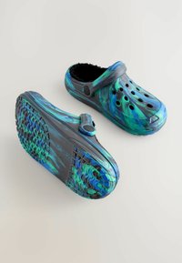 Saboți multicolore cu un model în spirală albastru și verde, fabricate dintr-un material ușor, cu orificii de ventilație și căptușeală pufoasă neagră.