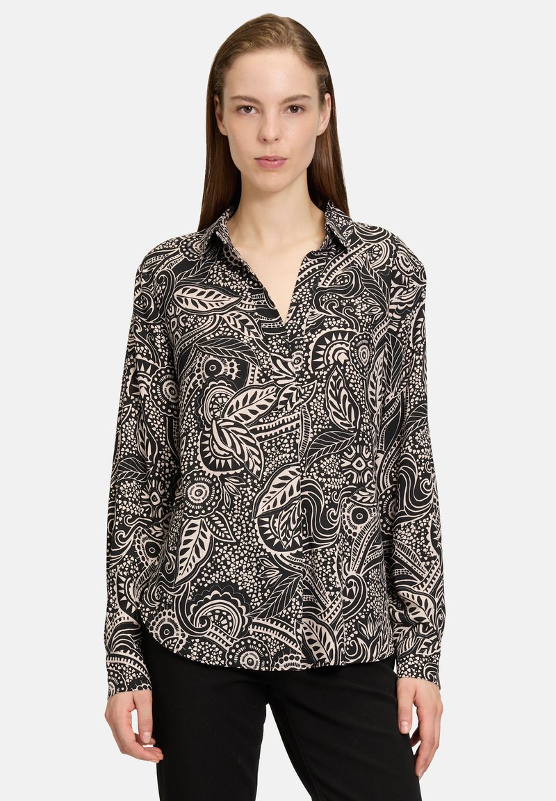 Zwarte en beige lange mouwen shirt met een ingewikkeld bloem- en abstract patroon, met een kraag en een relaxte pasvorm.