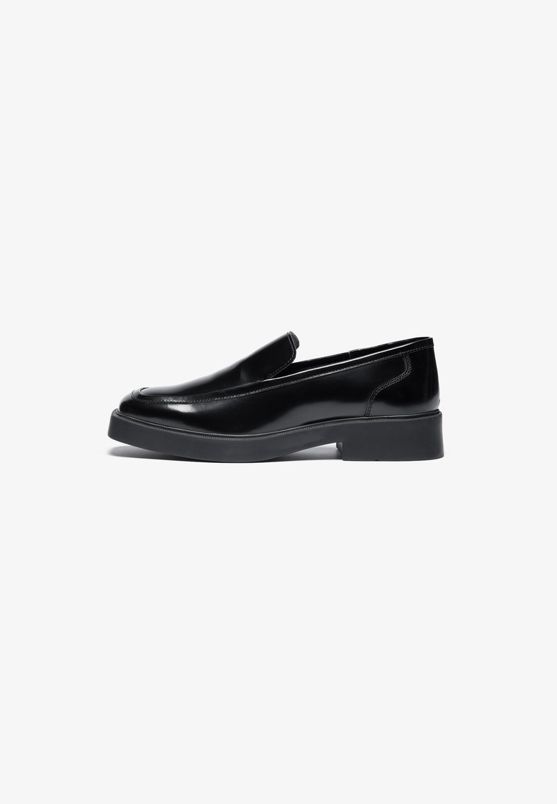 Pantofi negri din piele, cu sistem slip-on, vârful rotunjit și o talpă groasă din cauciuc, joasă. Textură netedă, cu detalii de cusătură minime.