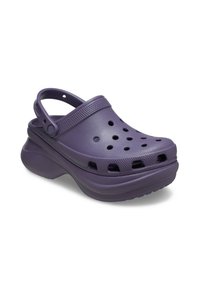 Paarse rubberen klompen met ventilatiegaten, een achterband en een verhoogde zool voor extra comfort en steun. Gladde oppervlaktextuur.