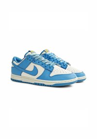 Sneakers Nike Dunk Low in pelle bianca e azzurra chiara. Le caratteristiche includono una punta forata, un collo imbottito e una suola in gomma.
