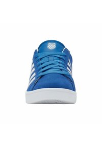 Blauer K-Swiss Sneaker mit weißen Streifen, flachen Schnürsenkeln und einer weißen Sohle, von vorne auf einem weißen Hintergrund dargestellt.