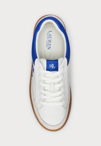 Vit sneaker med blå läderdetalj och logotyp. Har snörning framtill och sula av gummirubber. Mjukt inre foder.