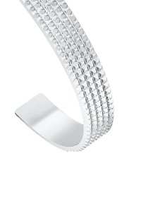 Silver cuff bracelet with a textured surface featuring a series of pyramidal indentations, smooth interior, and a modern curved shape.