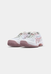 Hvite atletiske sko med rosa detaljer, mesh-stoff, snøring og teksturerte gummisåler, designet for komfort og ytelse.