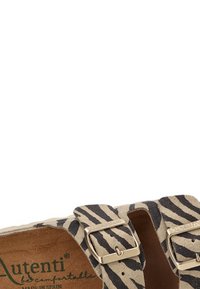 Sandal con estampado de cebra beige y negro, con dos hebillas metálicas ajustables, hecho de suave gamuza y con una plantilla acolchada para mayor comodidad.