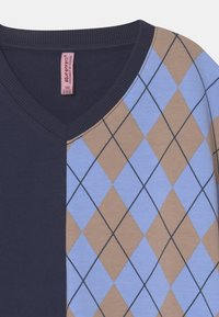 Námořnická a světle modrá tričko s výstřihem do V, které má rozdělený design s argyle vzorem v hnědé a světle modré barvě, z texturované bavlněné látky.