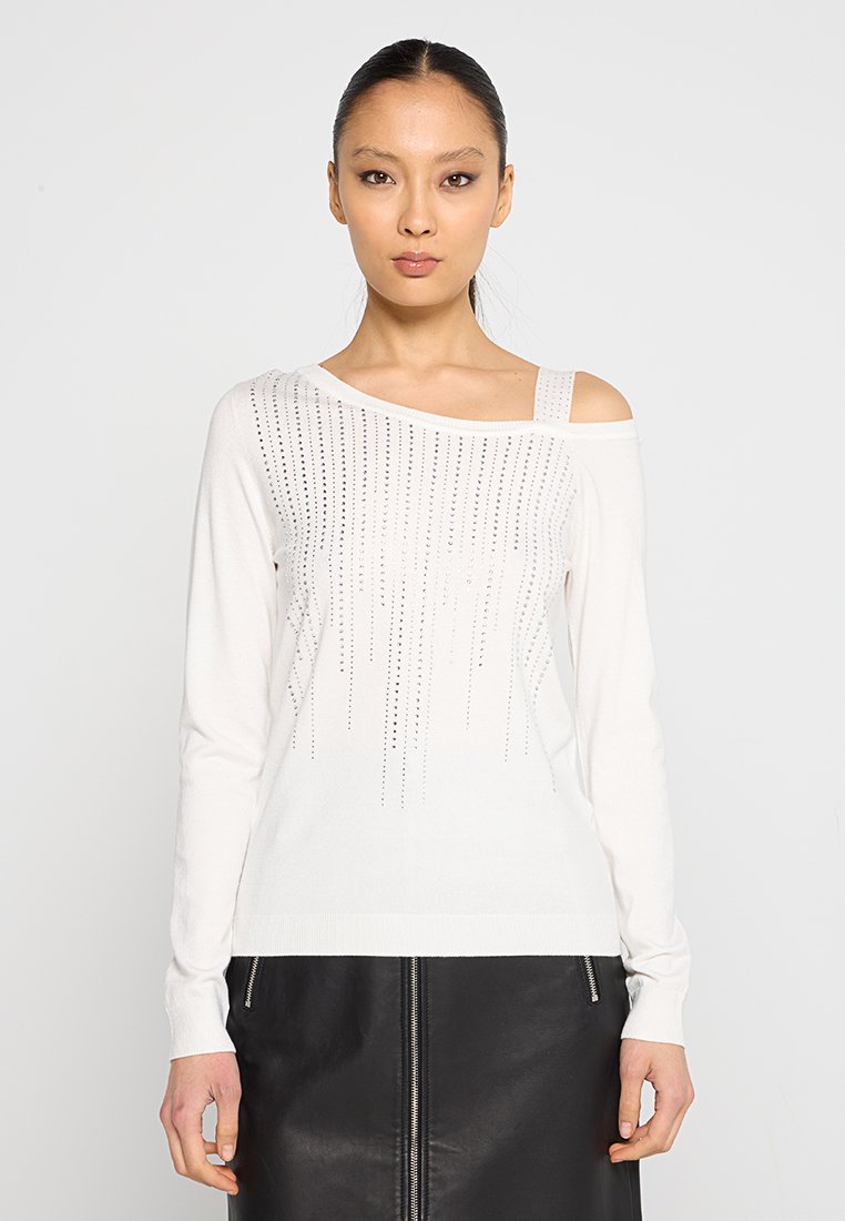 Off-white Langarmpullover mit asymmetrischem Ausschnitt, verziert mit silbernen Nieten, die ein vertikales Muster bilden. Weiches Strickmaterial.