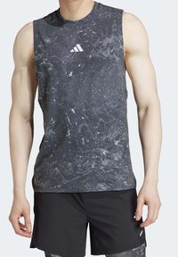 Harmaa hihaton urheilupaita, jossa on marmoroitu kuvio, ja rinnan kohdalla pieni valkoinen adidas-logo. Materiaali näyttää kevyeltä.