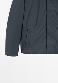 Dunkelgraue Jacke aus wasserabweisendem Material. Verfügt über einen Reißverschluss, Seitentaschen und eine glatte Textur. Schmale Passform mit minimalistischem Design.