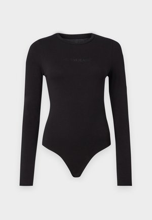 Černý body s dlouhým rukávem vyrobený z měkké tkaniny, s kulatým výstřihem a texturovaným logem "Guess Jeans" na přední straně.