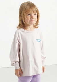 Ružičasta dugom rukavu majica s okruglim izrezom, s malim plavim logotipom "AMERICAN VINTAGE" sprijeda. Mekani pamučni materijal.