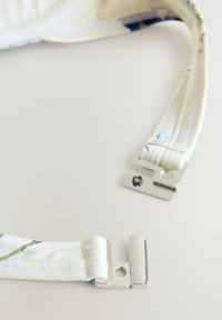 Verstelbare textielen banden in het wit met bloemmotieven, voorzien van zilveren metalen clips voor bevestiging, een zachte textuur en een stevige constructie.
