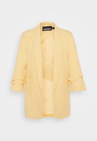 Gul kavaj med skräddarsydd design, slagkrage och trekvartslånga ärmar. Tillverkad av ett mjukt tyg, utan knäppningar.