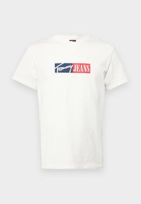 Biała bawełniana koszulka z prostokątnym logo w granatowym i czerwonym kolorze z napisem "Tommy JEANS". Klasyczny okrągły dekolt i krótkie rękawy.