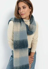 Blaue und beige Schal mit einer weichen, strukturierten Oberfläche. Verfügt über ein kariertes Muster und hängt locker um den Hals. Einfaches, warmes Design.