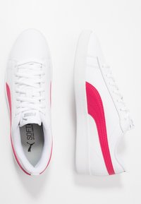 Białe sneakersy Puma z jasnoróżowym paskiem po bokach, przedstawione z widoku z góry i z boku na białym tle.