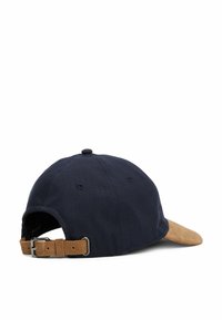 Cappellino da baseball blu navy con texture a spina di pesce, visiera in suede beige e cinturino regolabile marrone con fibbia in metallo sul retro.