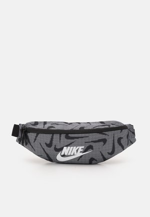 Szara i czarna nerka Nike z abstrakcyjnym wzorem zygzaków, górnym zamkiem błyskawicznym oraz białym logo Nike na środku przedniej części.