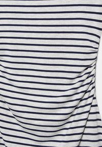 Szürke szövet, egyenletesen elhelyezkedő vízszintes tengerészkék csíkokkal, amelyek sima, enyhén gyűrött textúrát hoznak létre.