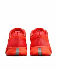 Een paar helderrode sportschoenen gezien vanaf de achterkant met grijze verticale reflecterende strepen op de hielen.