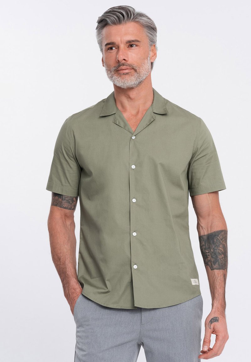 Kurzärmliges, knöpfbares Shirt aus Baumwolle in Salbeigrün, mit einem flachen Kragen, glatter Textur und weißen Knöpfen. Verfügt über ein kleines Etikett nahe dem Saum.