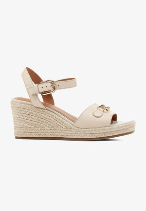 Sandales compensées en cuir beige avec talon en jute tissé, bout ouvert, bride de cheville réglable et détail en métal doré.