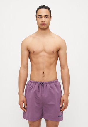 Shorts de bain violets avec un waistband élastique et un cordon de serrage, présentant un logo sur la jambe gauche et fabriqués à partir d'un tissu léger et doux.