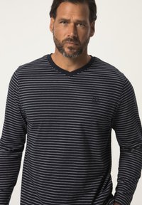 T-shirt à manches longues rayé bleu marine et blanc avec un col en V, doté d'un tissu texturé et d'un petit logo sur la poitrine.