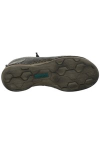 Suela de zapato negra con patrón hexagonal, que presenta goma texturizada y una etiqueta azul con la inscripción "Josef Seibel". Muestra desgaste con un borde ligeramente curvado.