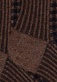 Calze a righe marroni con un motivo testurizzato e una finitura metallica. Il materiale sembra morbido, con accenti scuri a contrasto e zone a costine.