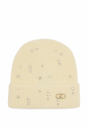 Kremowa czapka beanie ozdobiona klejnotami i perłami, z podwiniętym brzegiem i małą metką z logo po boku.