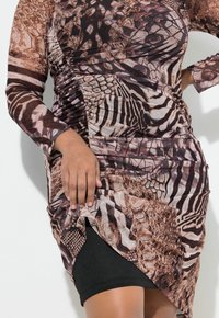 Das Langarmkleid weist eine Mischung aus Tierdrucken in Braun und Schwarz auf, gefertigt aus leichtem Stoff, mit raffinierten Details und einem asymmetrischen Saum.