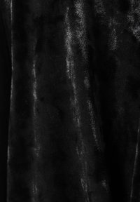 Črna tkanina z mehko, puhasto teksturo, ki ima subtilen sijaj in rahle barvne variacije po površini. Brez vidnih vzorcev ali podrobnosti.